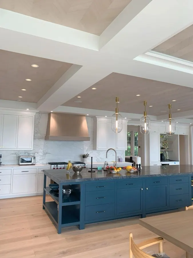 Custom kitchen remodel with pendant lighting over a navy island