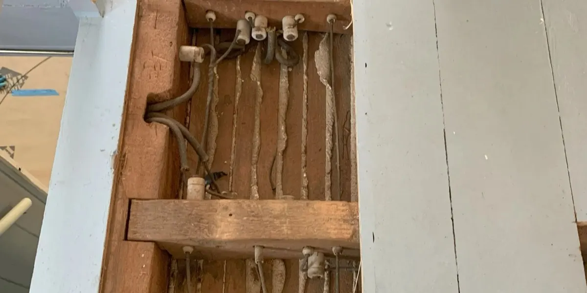 Old knob and tube wiring exposed in a wall cavity during a rewire