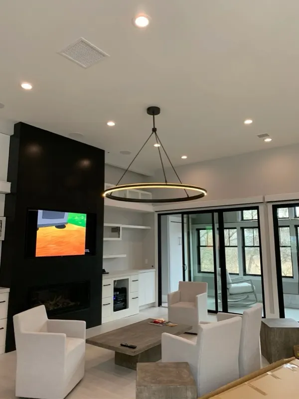 Modern living room remodel with recessed lighting, wall-mounted TV, and fireplace